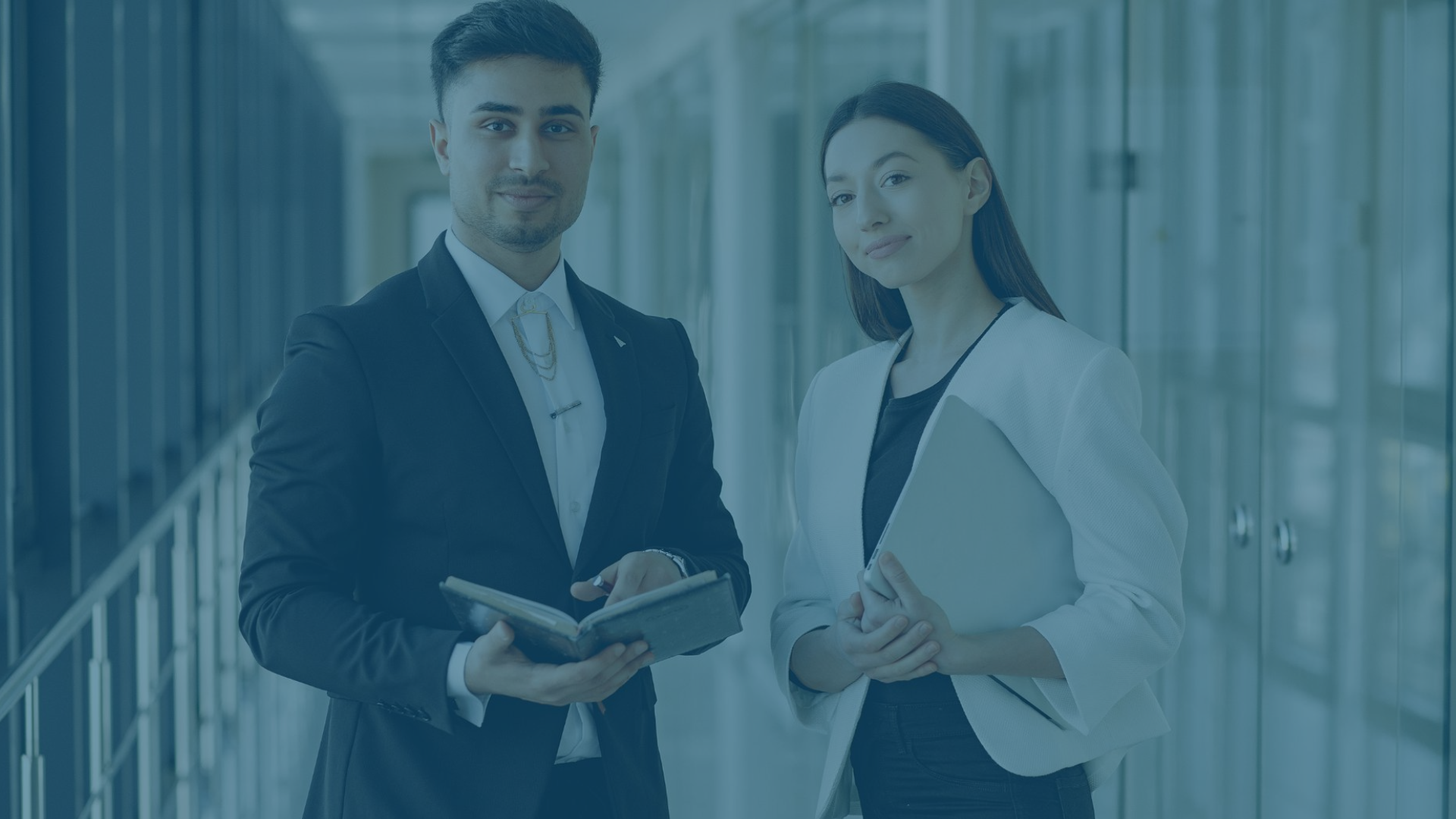 Mann und Frau im Business-Look lächeln in die Kamera