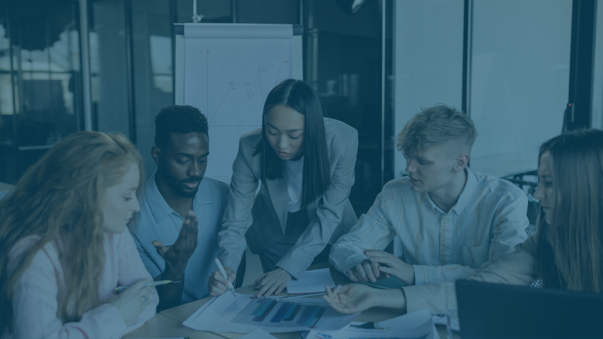 Menschen besprechen am Tisch eine Datengrafik zusammen